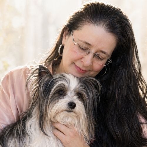 Nahaufnahme einer Frau mit ihrem alten Hund, beide ruhig und verbunden, Ausdruck von Vertrauen und Geborgenheit